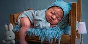 Lyam participe au concours pour gagner de l'argent avec cette photo : baby, bed, blanket, bonnet, clothing, crib, cushion, face, furniture, hat, head, homedecor, infantbed, lamp, newborn, person, photography, portrait, sleeping, toy