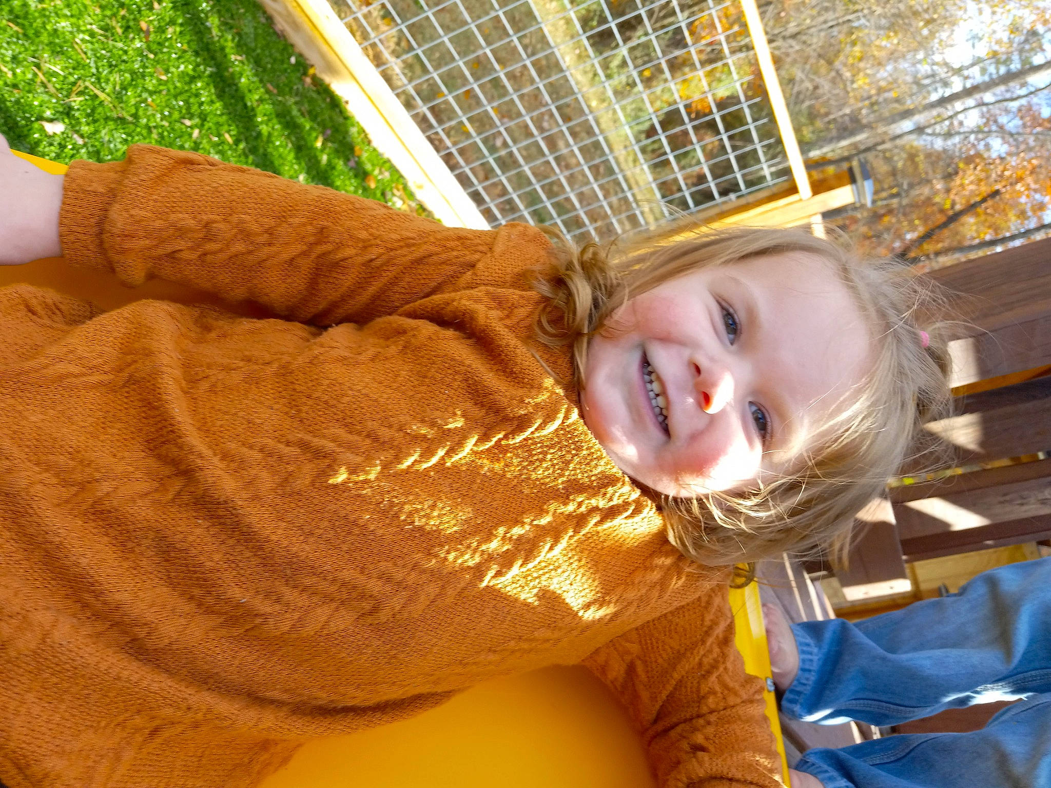 Armani is registered to the contest to win money with this photo: blond, child, city, eye, facial_expression, flooring, fun, grass, happy, joy, leisure, pattern, people_in_nature, person, play, recreation, sitting, smile, toddler, tree