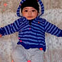 Kingston is registered to the contest to win money with this photo: baby, child, hoodie, striped_clothing, blue, gray_pants, socks, black_hat, blanket, fur_texture, lying_down, indoor, cute, face, eyes, hands, legs, heart_overlay, cozy, portrait