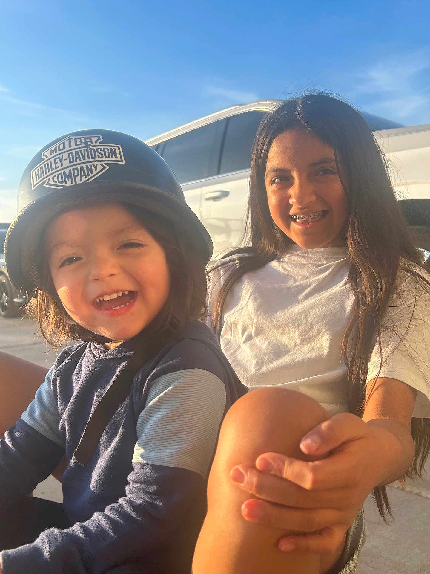 Samuel joined the competition — help win amazing prizes! child, helmet, smile, braces, outdoor, sunlight, happy, person, blue_sky, vehicle, white_car, casual_clothing, long_hair, joyful, sitting, daylight, face, young, motorcycle_helmet, friendship