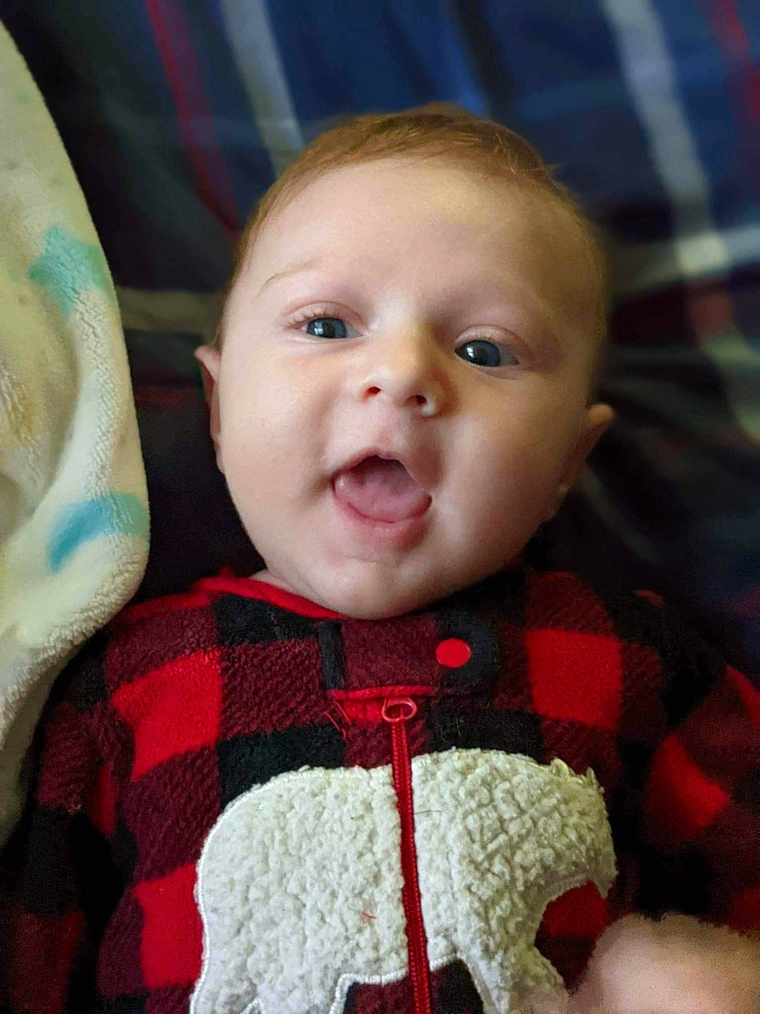 Lincoln is registered to the contest to win money with this photo: baby, baby_toddler_clothing, carmine, cheek, child, close_up, eyelash, happy, iris, linens, lip, nose, pattern, person, plaid, skin, sleeve, smile, toddler, wool