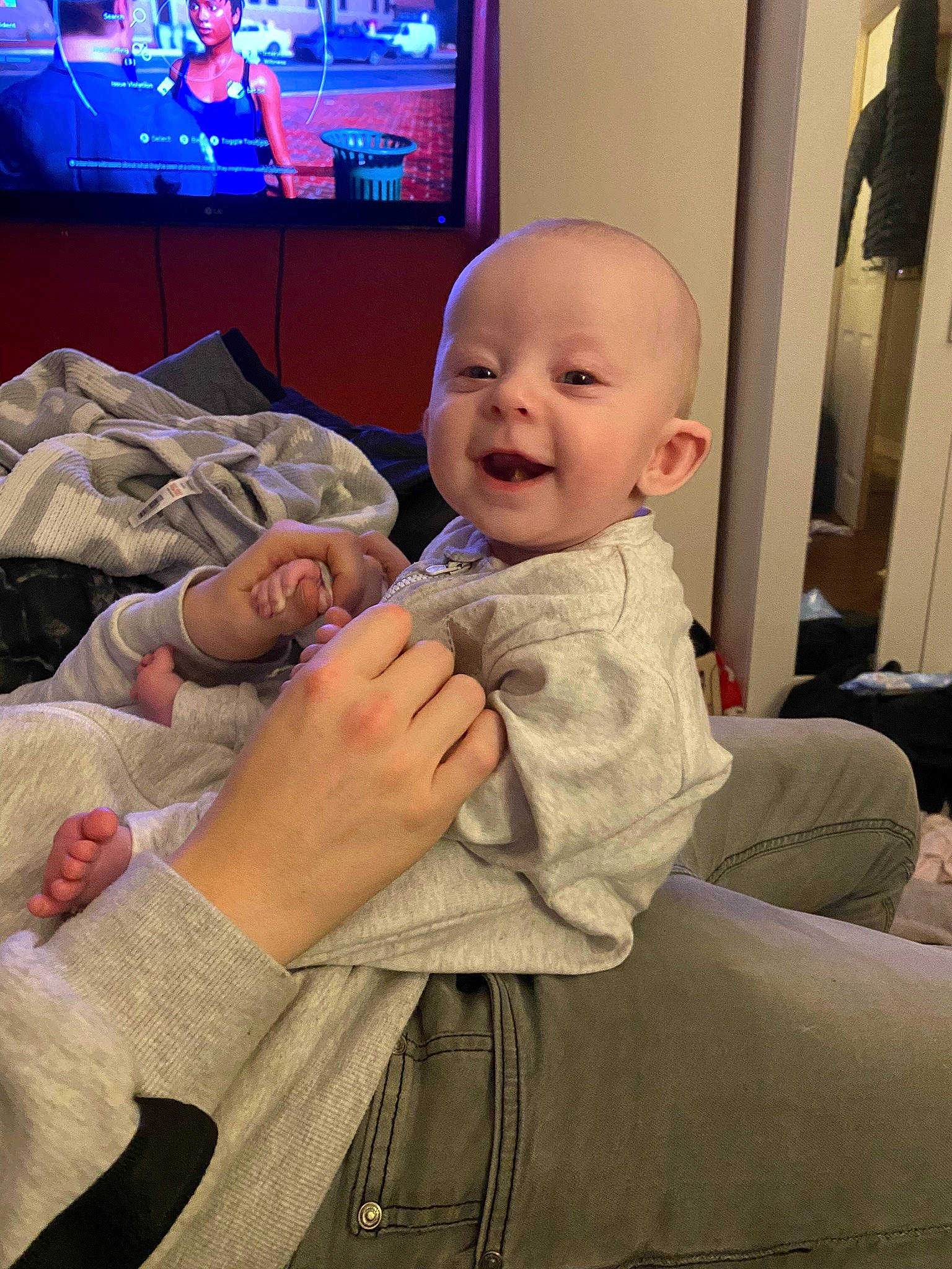 Amelia-grace is registered to the contest to win money with this photo: baby, baby_toddler_clothing, cheek, child, comfort, display_device, finger, flat_panel_display, fun, gesture, home_appliance, living_room, person, room, sitting, skin, smile, television, television_set, thumb