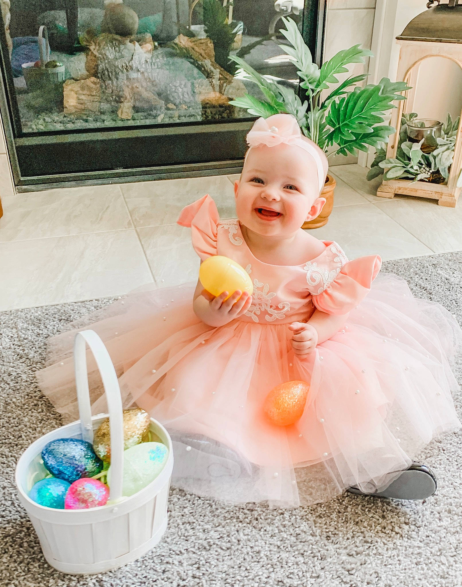 Charlotte is registered to the contest to win money with this photo: baby, baby_products, baby_toddler_clothing, bathing, child, dress, event, fun, happy, household_supply, houseplant, joy, peach, person, photograph, pink, plant, sitting, smile, summer