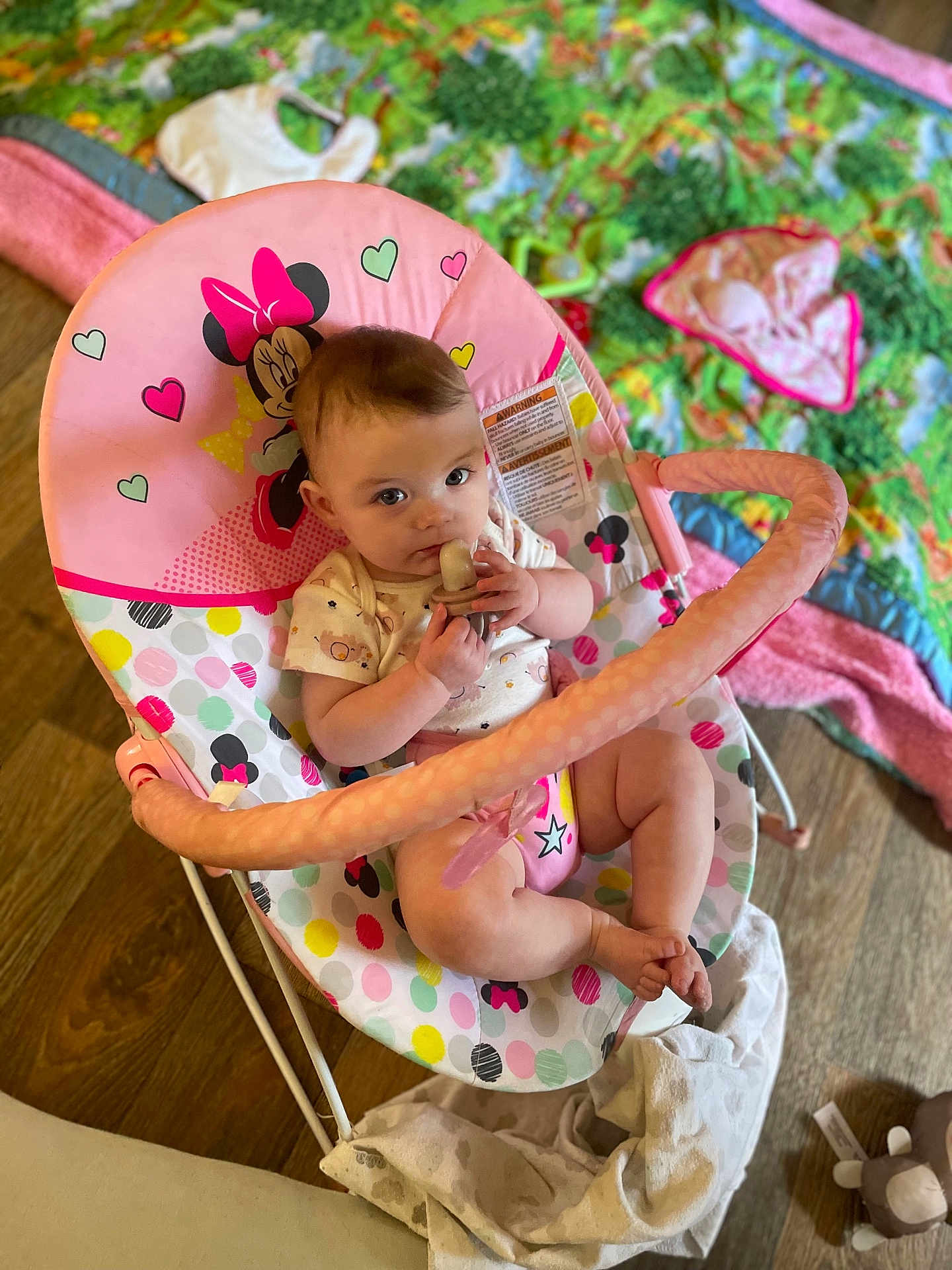Alice joined the competition — help win amazing prizes! baby, infant, pacifier, baby_chair, minnie_mouse, colorful, playmat, toy, floor, wooden_floor, clothing, cute, child, indoors, looking_up, sitting, pink, white, patterned, comfort