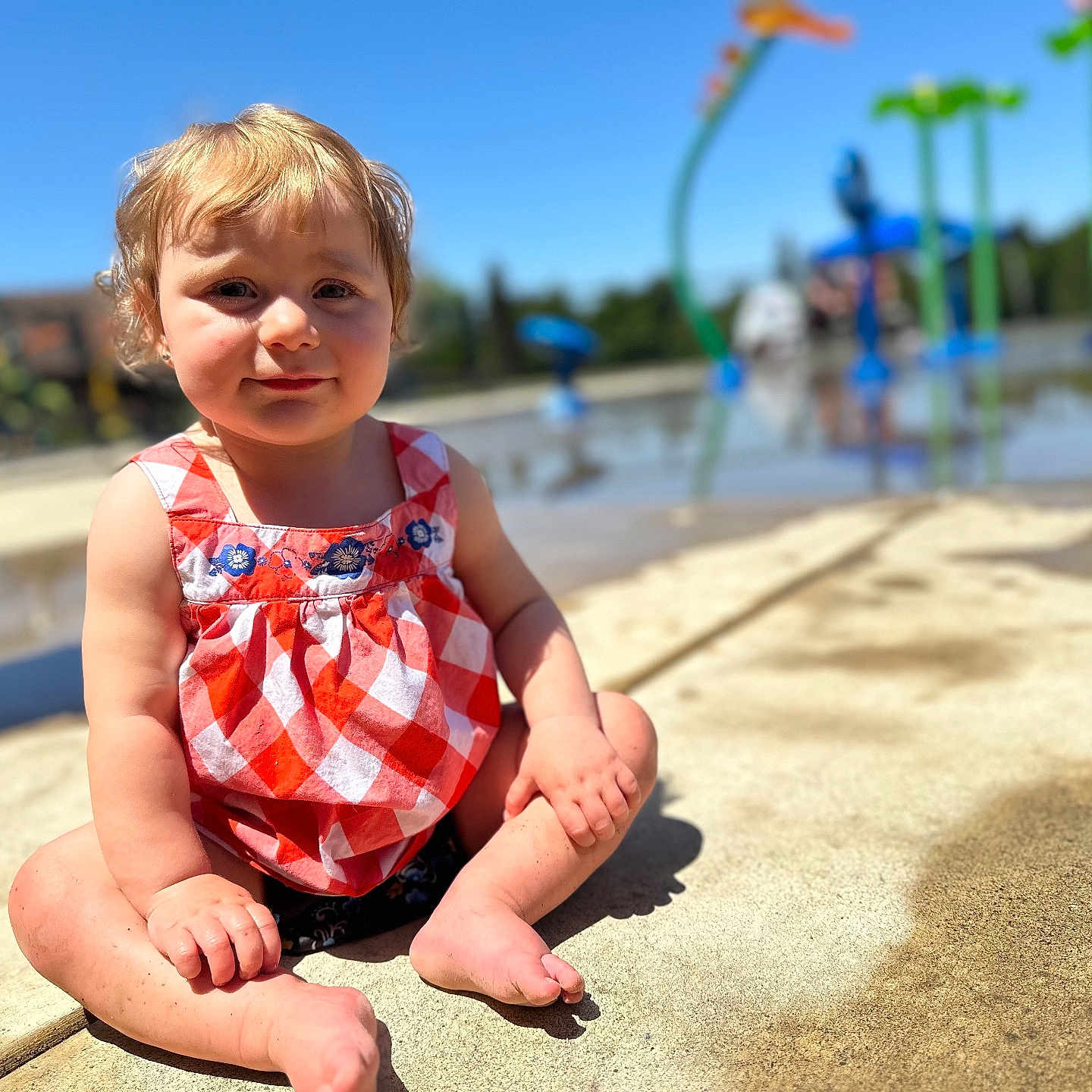 Adalynn is registered to the contest to win money with this photo: baby, beachwear, bodypart, clothing, dress, face, finger, grass, hand, head, outdoorplayarea, outdoors, person, photography, plant, playarea, portrait, sitting, summer, water