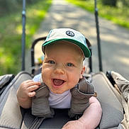 Marc participe au concours pour gagner de l'argent avec cette photo : baby, baby_seat, blue_eyes, cap, child, clothing, cute, daylight, face, greenery, hand, happy, infant, nature, outdoor, pathway, portrait, smiling, stroller, sunlight