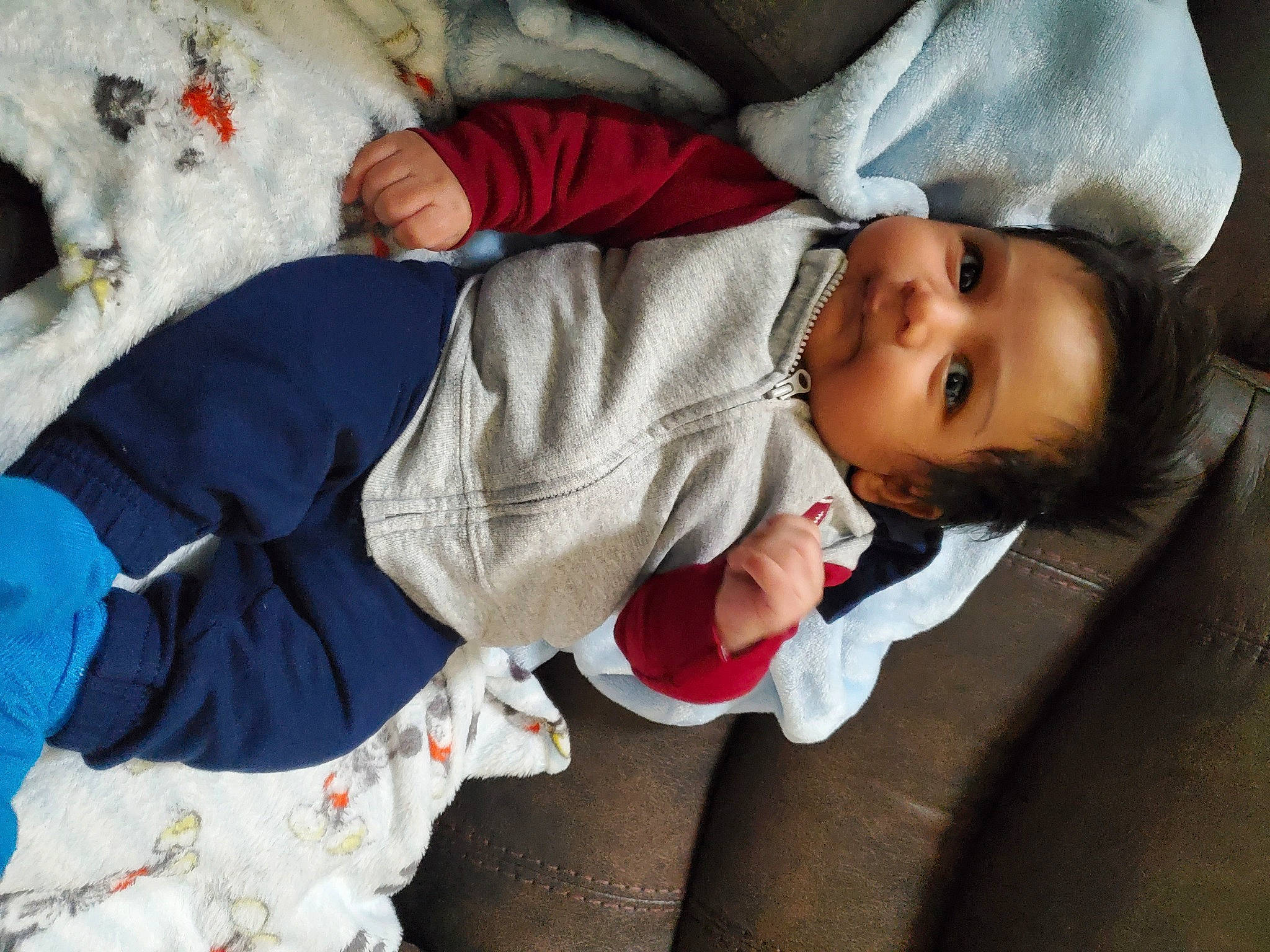 Leonardo is registered to the contest to win money with this photo: baby, baby_products, baby_toddler_clothing, child, comfort, event, eye, fun, fur, happy, human_body, linens, outerwear, person, room, sitting, sleeve, smile, toddler, tree