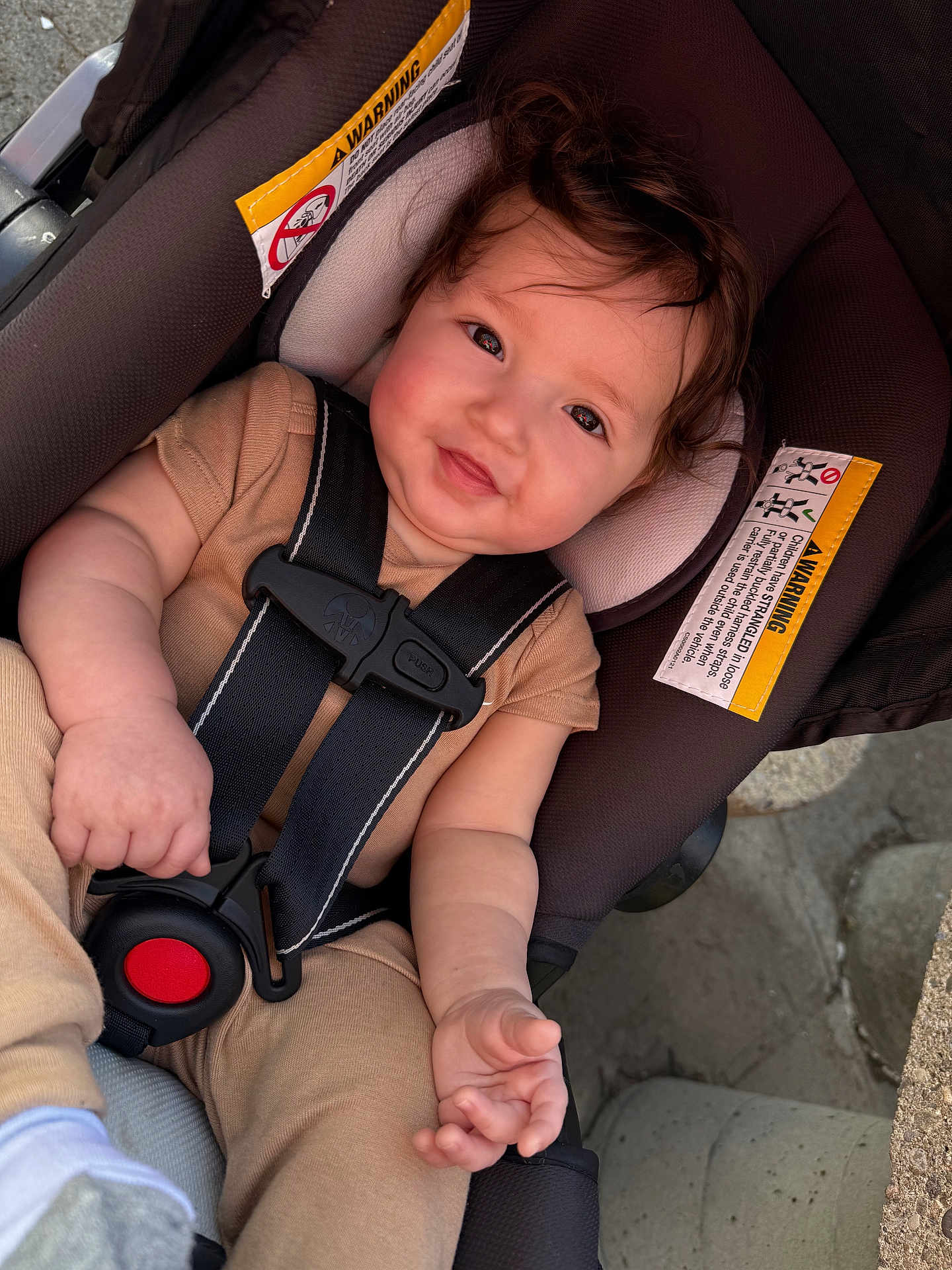 Jayceon joined the competition — help win amazing prizes! baby, child, car_seat, safety_harness, smile, face, hands, clothing, curly_hair, rosy_cheeks, infant, seatbelt, warning_label, outdoor, cute, person, closeup, toddler, seat, soft_lighting