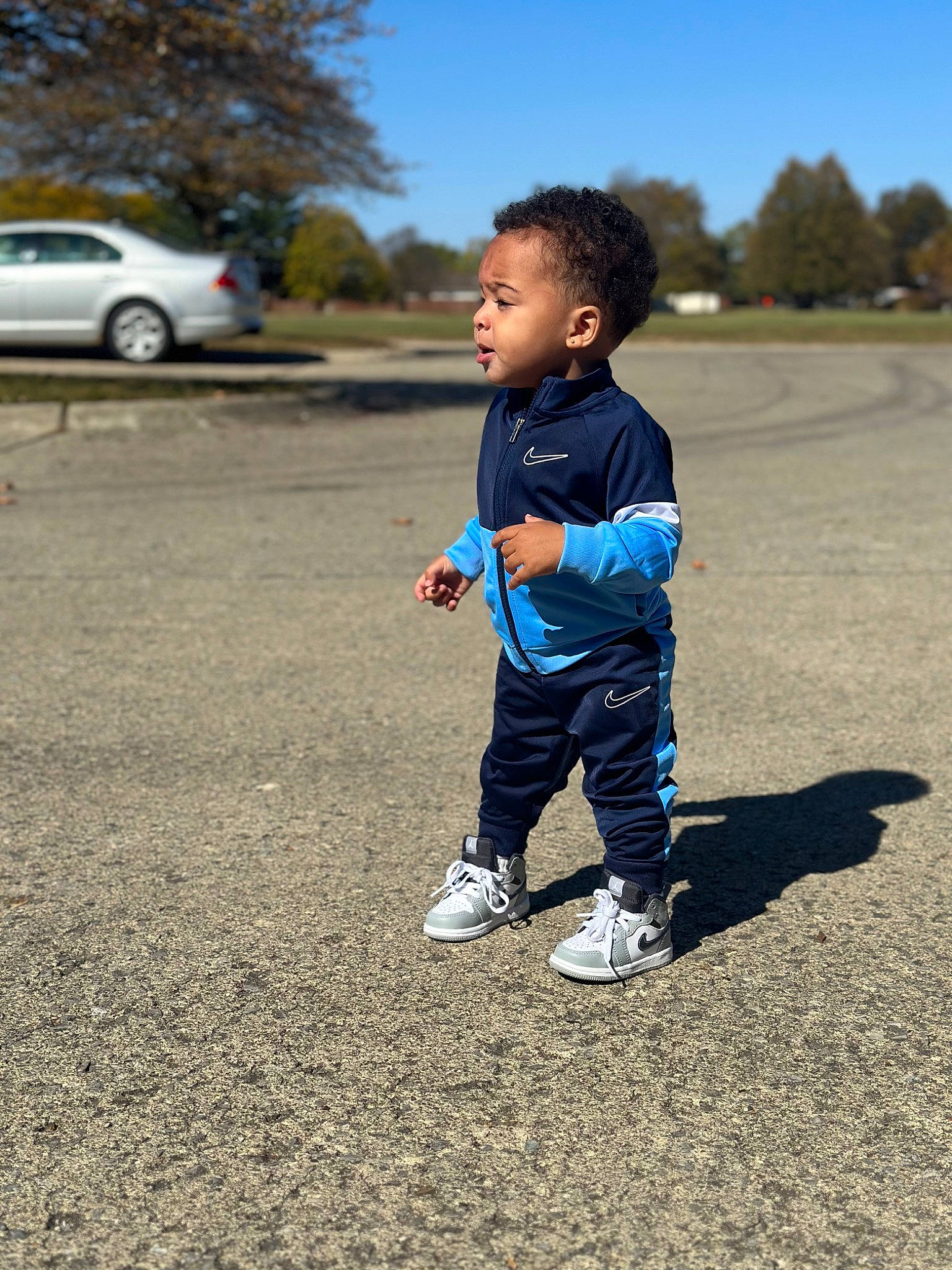 Jaceon is registered to the contest to win money with this photo: asphalt, baby_toddler_clothing, car, electric_blue, fun, grass, happy, landscape, leisure, people_in_nature, person, recreation, road_surface, sky, t_shirt, tire, toddler, tree, vehicle, vehicle_door