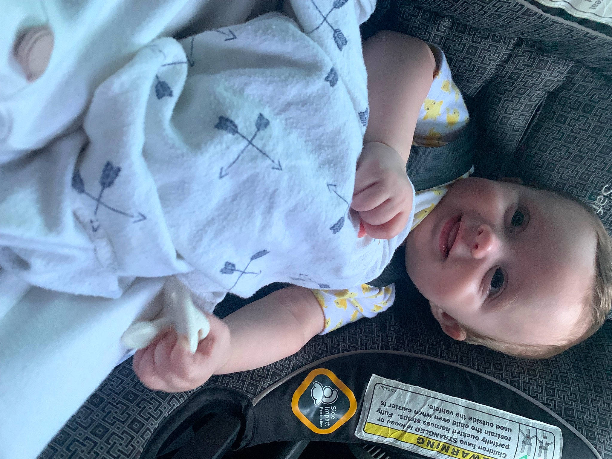 Justin is registered to the contest to win money with this photo: baby, baby_products, baby_toddler_clothing, cheek, child, comfort, facial_expression, finger, gesture, nail, pattern, person, sitting, skin, sleeve, smile, toddler, tree, white