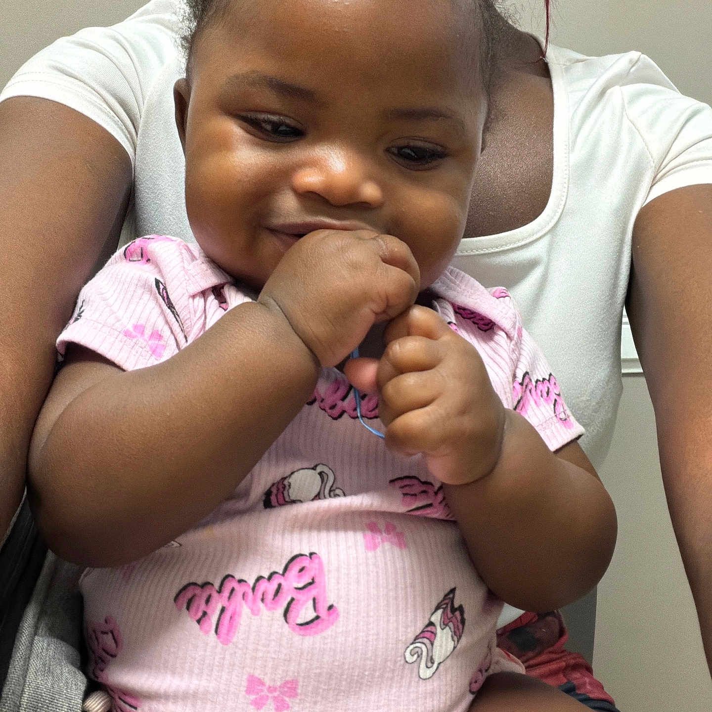 Vanessa joined the competition — help win amazing prizes! baby, child, infant, person, smile, hand, clothing, pink, onesie, pattern, indoor, adult, holding, cute, face, skin, hair, portrait, happy, toddler