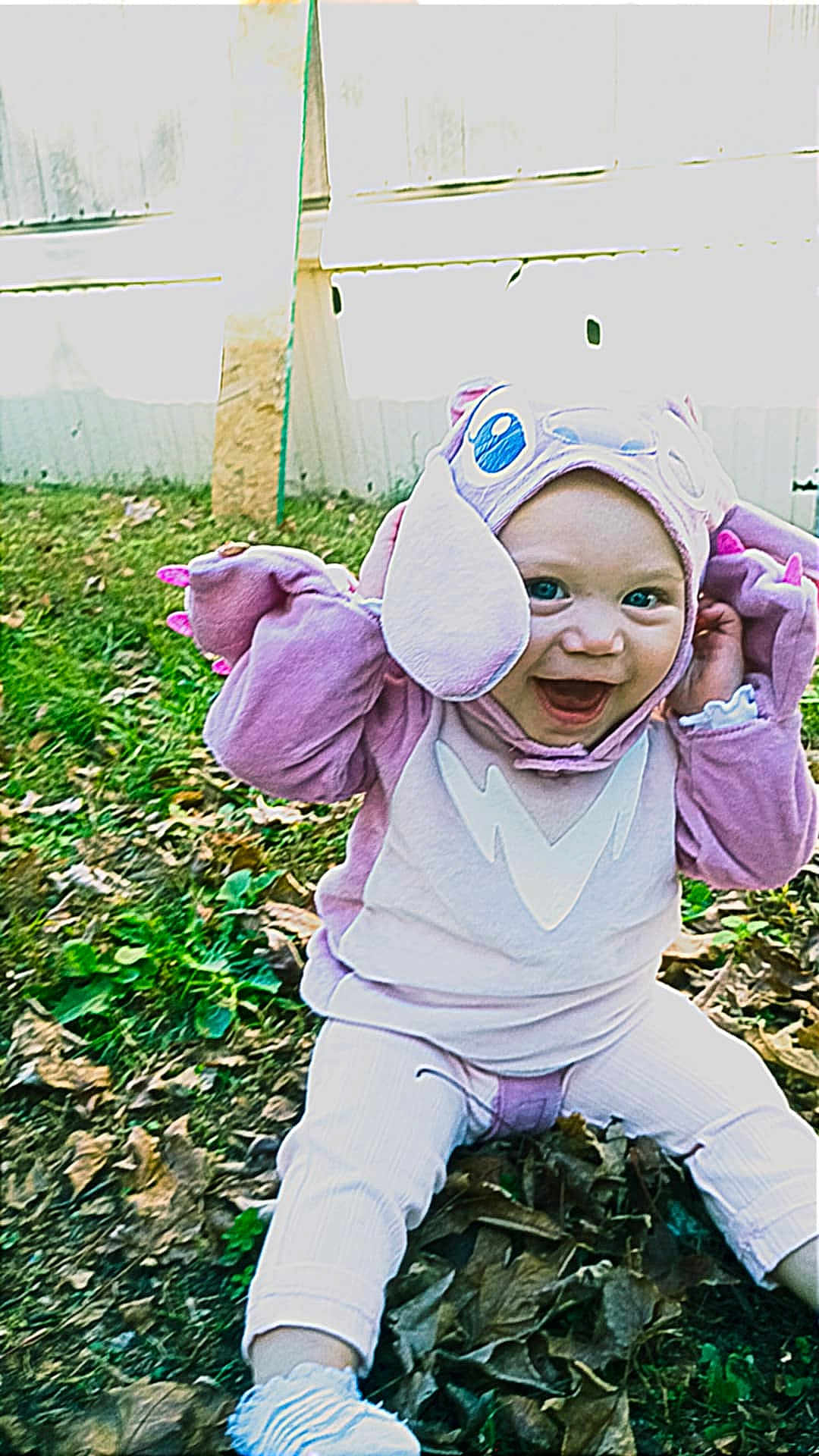 Freya Ray Smith joined the competition — help win amazing prizes! baby, child, costume, purple, smiling, outdoor, leaves, grass, playful, cute, happy, sitting, person, headwear, animal_costume, fall, nature, baby_clothes, fun, expression