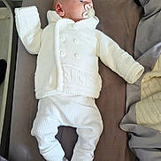Kai joined the competition — help win amazing prizes! baby, infant, pacifier, white_clothing, knitted_sweater, pants, socks, bed, blanket, sleepwear, lying_down, indoors, resting, child, newborn, cute, peaceful, soft_fabric, portrait, young