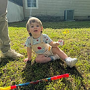 Stephen joined the competition — help win amazing prizes! toddler, child, grass, toy, ball, golf_club, sunlight, shadow, adult_legs, shoes, outdoor, backyard, house, window, pants, shirt, footwear, play, daytime, nature