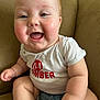 Isabella joined the competition — help win amazing prizes! baby, child, smiling, happy, couch, white_shirt, red_text, sitting, indoor, closeup, chubby, cute, face, arms, legs, infant, person, casual_clothing, comfortable, joyful