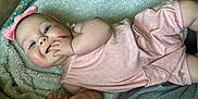 Isabella is registered to the contest to win money with this photo: baby, infant, child, pink_clothing, headband, blanket, hand, face, cheeks, skin, eyes, lying_down, soft_texture, cute, adorable, fingers, happy, indoors, portrait, closeup