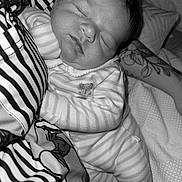 Albie is registered to the contest to win money with this photo: newborn, baby, sleeping, striped_clothing, tattoo, arm, blanket, fabric, bed, monochrome, portrait, rest, infant, comfort, soft_texture, close_up, peaceful, face, person, indoor