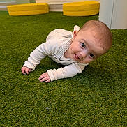 Luca is registered to the contest to win money with this photo: baby, child, crawling_position, curious, cute, floor, green_carpet, hands, head, indoor, infant, person, play_area, smiling, soft_lighting, tongue_out, white_clothing, wide_eyes, yellow_cushions, young_child