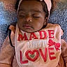 Genesis is registered to the contest to win money with this photo: baby, sleeping, infant, pink_clothing, headband, bow, bib, textile, blanket, cozy, cute, child, portrait, indoor, peaceful, soft_lighting, close_up, adorable, resting, young_child