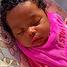 baby, sleeping, curly_hair, pink_bib, infant, close_up, cute, child, resting, cozy, portrait, soft_lighting, indoors, animal_pattern, baby_seat, peaceful, young_child, face, cute_expression, toddler
