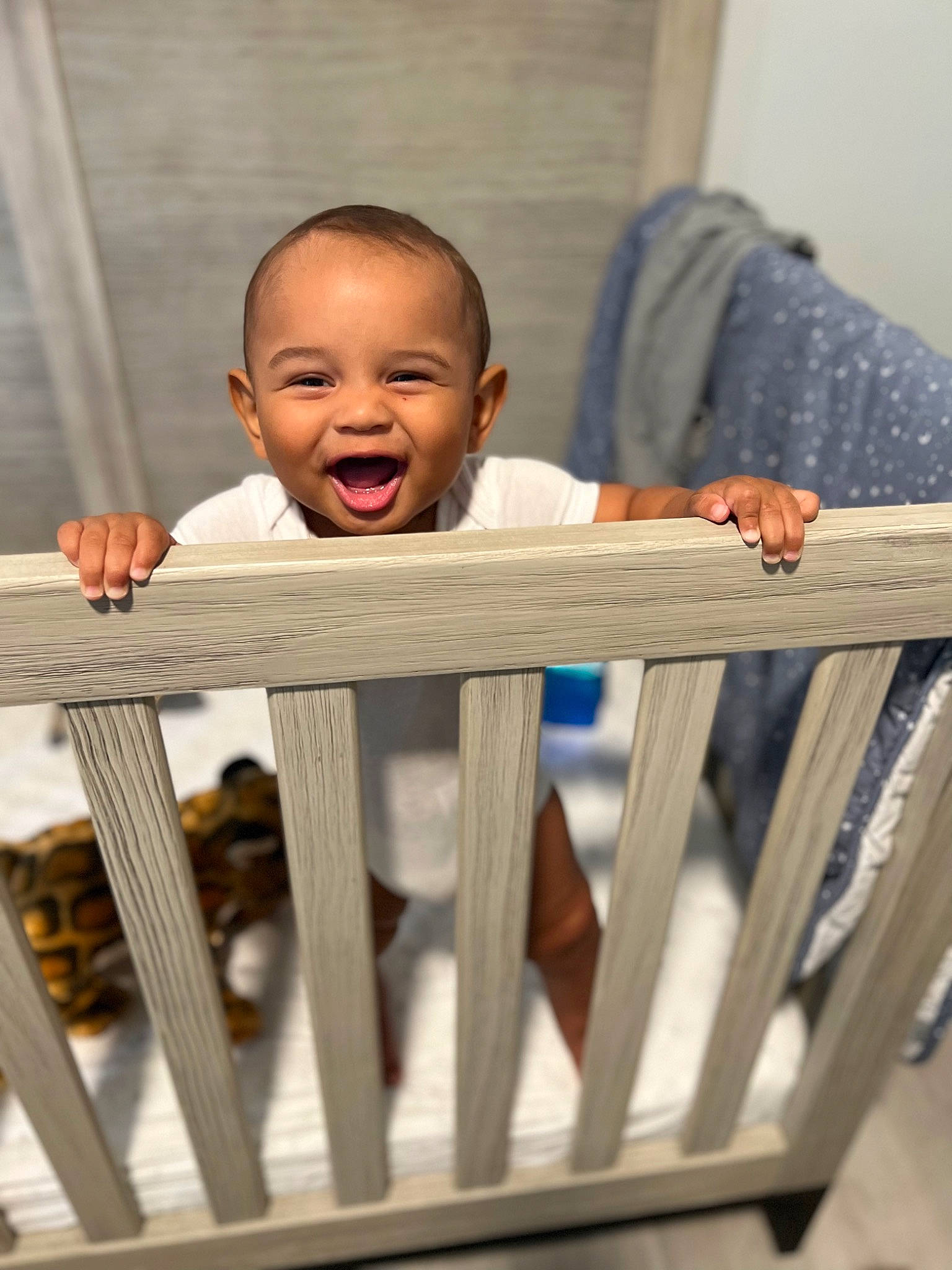 Kyree is registered to the contest to win money with this photo: baby_safety, baby_toddler_clothing, clothing, cradle, eye, facial_expression, fence, hand, happy, head, human_body, infant_bed, nursery, person, product, skin, sleeve, smile, standing, toddler