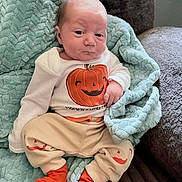 Wyatt joined the competition — help win amazing prizes! baby, infant, blanket, couch, clothing, pumpkin, orange, socks, face, person, indoors, cute, plush, relaxing, seated, soft, newborn, expression, cozy, home
