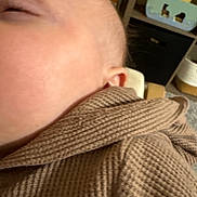 Kasen is registered to the contest to win money with this photo: baby, infant, close_up, cheek, ear, eyelid, skin, blurry, brown_cloth, waffle_texture, cozy, sleeping, nursery, toy, shelf, indoor, portrait, soft_fabric, face, handheld_photo