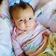 Mylee joined the competition — help win amazing prizes! baby, infant, blue_eyes, bows, pink_blanket, cartoon_characters, soft_texture, pastel_clothing, smirk, cute, child, portrait, indoors, cozy, sleepwear, hand, face, head, lying_down, comfortable