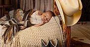 Atticus joined the competition — help win amazing prizes! baby, sleeping, blanket, knitted, wooden_bed, cowboy_hat, cowboy_boots, rustic, cozy, nursery, brown, beige, plaid_clothing, soft_lighting, indoor, decor, western_theme, infant, peaceful, cute