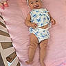 Lily is registered to the contest to win money with this photo: baby, child, crib, blanket, pink, headband, smile, happy, plush_toy, blue, white, butterfly_pattern, infant, clothing, lying_down, cute, soft, indoors, toddler, comfort