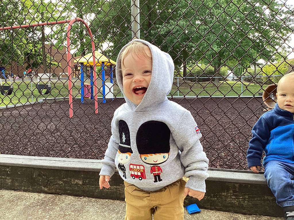 John joined the competition — help win amazing prizes! baby, child, city, eye, face, fun, garden, grass, happy, leisure, outdoor_play_equipment, person, plant, play, recreation, sitting, smile, summer, t_shirt, toddler