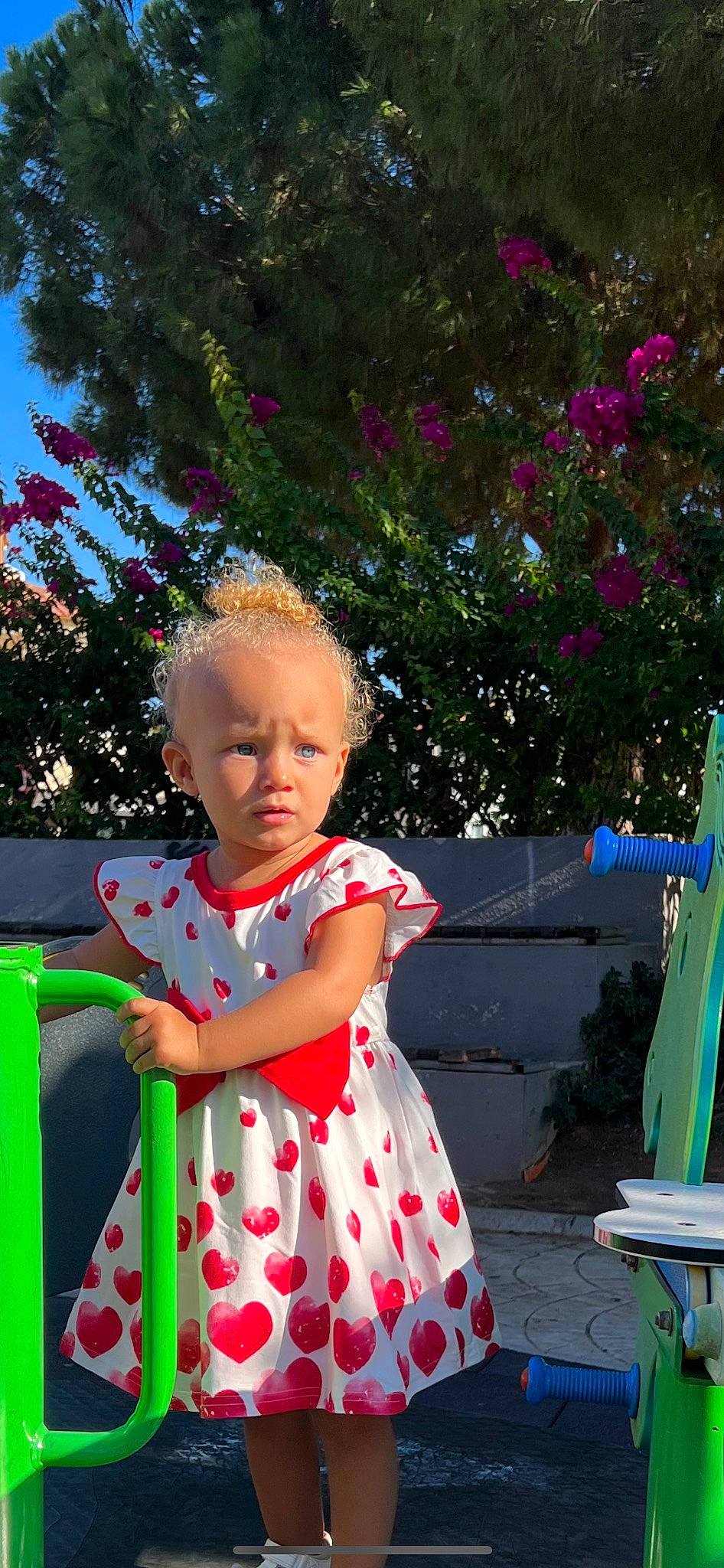 Kamari is registered to the contest to win money with this photo: baby, baby_toddler_clothing, botany, facial_expression, flower, fun, grass, green, happy, leisure, magenta, people_in_nature, person, pink, plant, recreation, red, sky, sorrow, standing