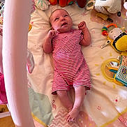 Eleanor a rejoint le concours — aidez-le/la à gagner de superbes lots ! baby, infant, striped_clothing, plush_toy, play_mat, colorful, pink, soft_toys, infant_garment, baby_accessories, floor, wooden_floor, toy, child, lying_down, cute, indoors, small_person, looking_up, raised_arms