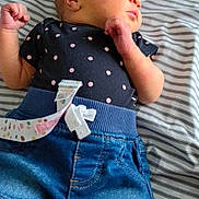 Harmony is registered to the contest to win money with this photo: newborn, baby, sleeping, polka_dot, shirt, denim_shorts, bed, striped_sheet, pillow, colorful, pattern, infant, cute, clothing, relaxing, peaceful, skin, head, hand, lying_down
