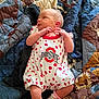 Harmony is registered to the contest to win money with this photo: baby, newborn, infant, blanket, quilt, clothing, romper, socks, pink, red, white, polka_dots, logo, laying_down, cute, small, skin, face, person, indoors