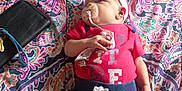 Harmony joined the competition — help win amazing prizes! baby, infant, pacifier, headband, clothing, bedspread, pattern, denim_shorts, red_shirt, lying_down, indoor, person, cute, small, hand, face, skin, colorful, fabric, resting