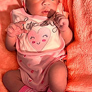 Amiyah is registered to the contest to win money with this photo: baby, infant, pink_clothing, headband, socks, blanket, soft_texture, cute, portrait, indoor, newborn, face, hands, lying_down, cozy, baby_girl, expression, closeup, warm_colors, sleepwear