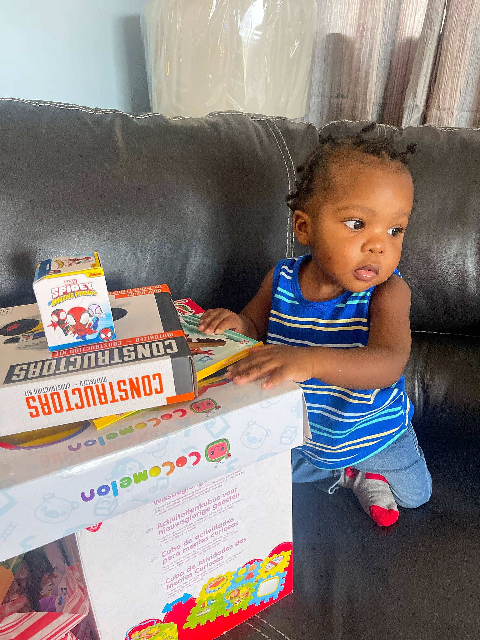 Roderick is registered to the contest to win money with this photo: box, child, comfort, couch, electric_blue, flooring, font, fun, happy, living_room, person, play, publication, reading, room, sitting, t_shirt, toddler