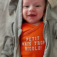 Lenny a rejoint le concours — aidez-le/la à gagner de superbes lots ! baby, blanket, closeup, cute, eyes, fabric, face, french_text_on_clothing, hand, hood, hoodie, indoor, infant, lying_down, mouth, onesie, orange_onesie, smiling, towel, zipper