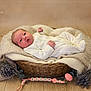 baby, newborn, infant, basket, blanket, wood_floor, knitted_fabric, lavender, soft_toys, white_clothing, sleepwear, portrait, cute, resting, peaceful, indoors, cozy, props, baby_accessories, warm_tones