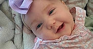 Belladonna is registered to the contest to win money with this photo: baby, bow, smile, blanket, infant, cute, child, face, portrait, pink, clothing, happy, soft, cozy, lying_down, closeup, headband, skin, expression, young