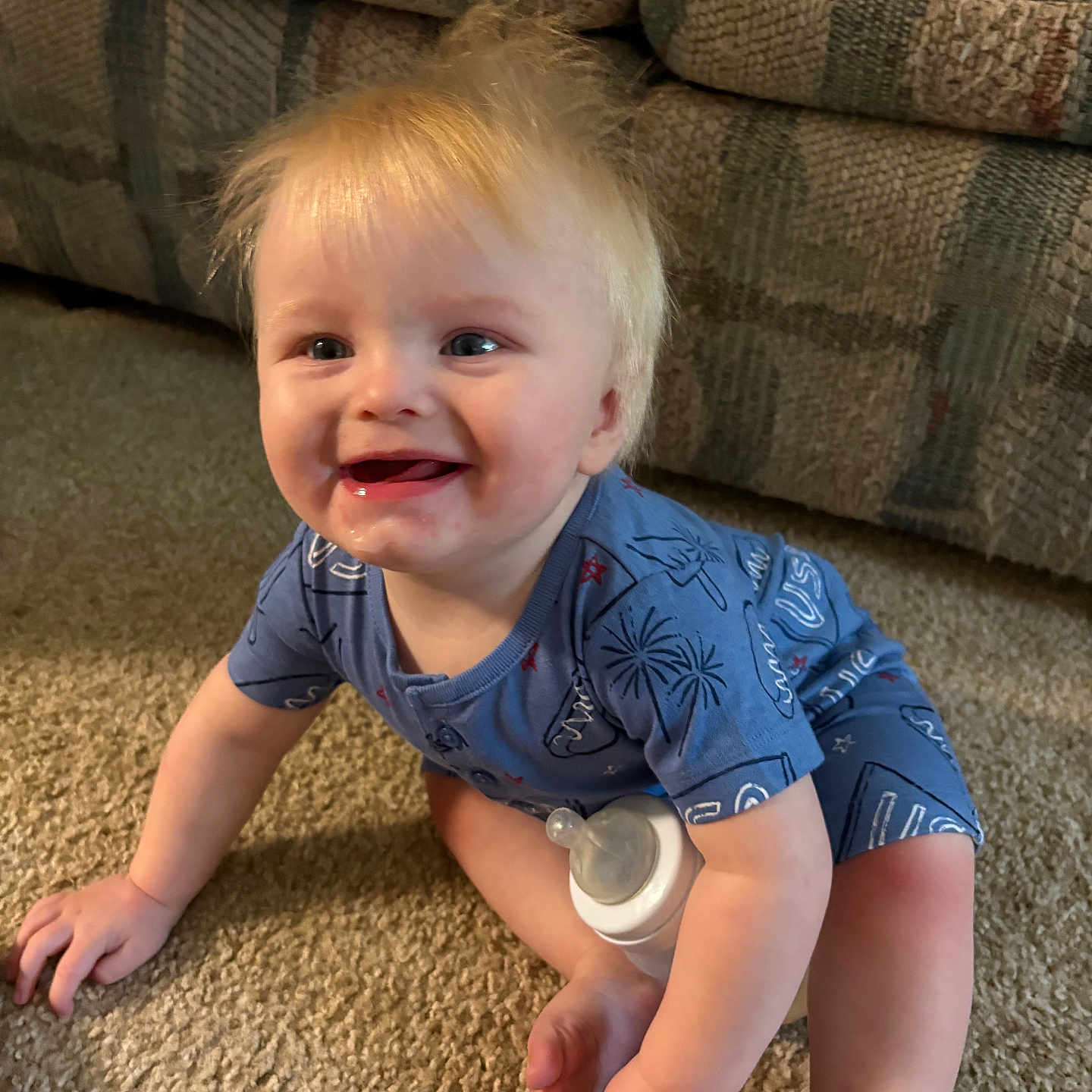 Michael joined the competition — help win amazing prizes! baby, child, crawling, smiling, blonde_hair, indoor, carpet, bottle, onesie, blue_clothing, happy, person, cute, toddler, living_room, furniture, couch, skin, hand, foot