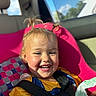 toddler, child, car_seat, smiling, happy, sunlight, hair, pigtails, seatbelt, car_interior, window, blue_sky, daylight, clothing, yellow_shirt, face, portrait, baby, cute, fun