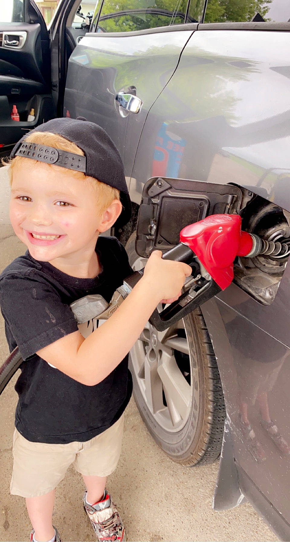 Dawson is registered to the contest to win money with this photo: alloy_wheel, auto_part, automotive_design, automotive_exterior, automotive_lighting, automotive_tire, automotive_wheel_system, bumper, car, fender, hat, headwear, hood, joy, motor_vehicle, person, rim, shorts, smile, tire