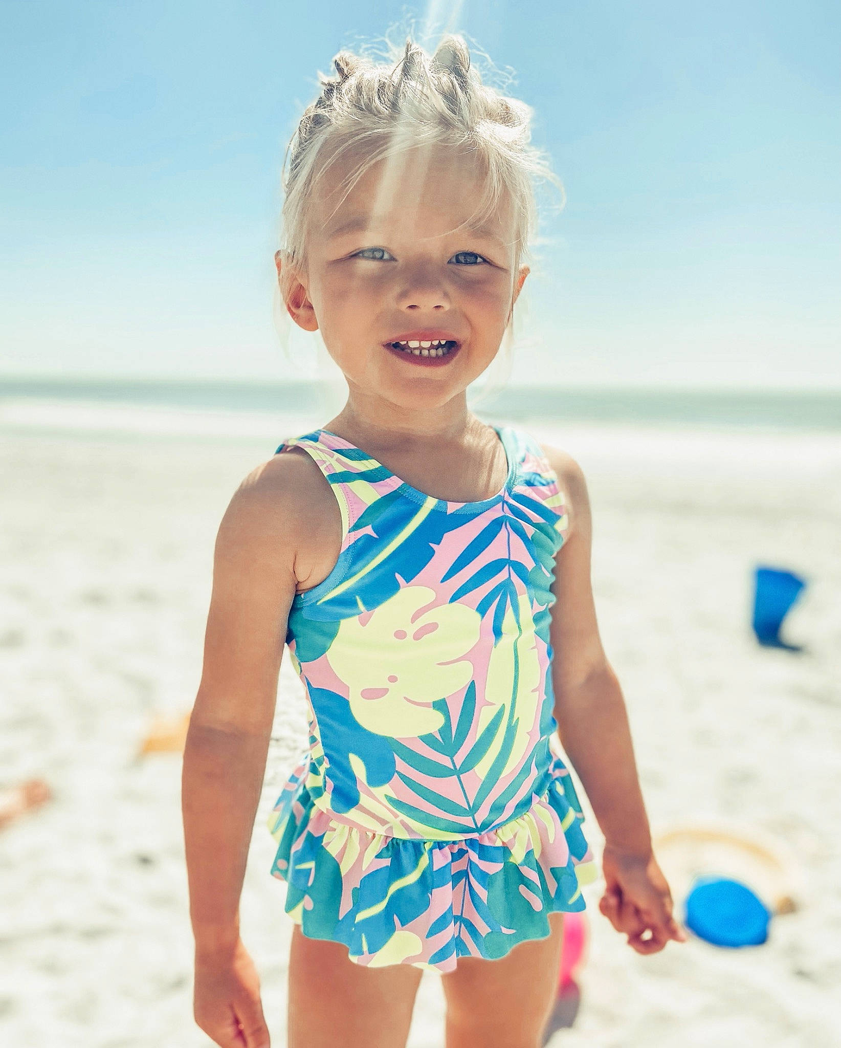 Blakelee is registered to the contest to win money with this photo: azure, baby_toddler_clothing, beach, blond, blue, body_of_water, electric_blue, fun, hair, happy, joy, one_piece_swimsuit, people_on_beach, person, sand, sky, smile, standing, summer, swimwear