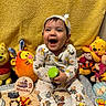 baby, child, smiling, sitting, plush_toys, winnie_the_pooh, tiger, piglet, clothing, headband, yellow_background, toy_bottle, 9_months, happy, cute, indoors, celebration, colorful, cartoon, portrait