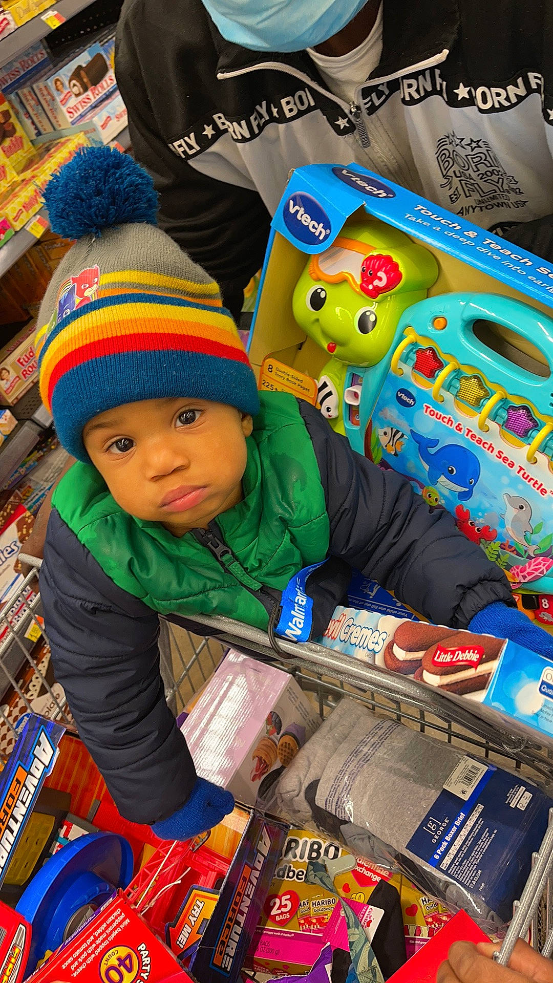 Jahvari is registered to the contest to win money with this photo: baby, baby_toddler_clothing, blue, cap, child, convenience_store, customer, event, fun, headwear, holiday, jacket, market, natural_foods, person, play, product, retail, service, shopping