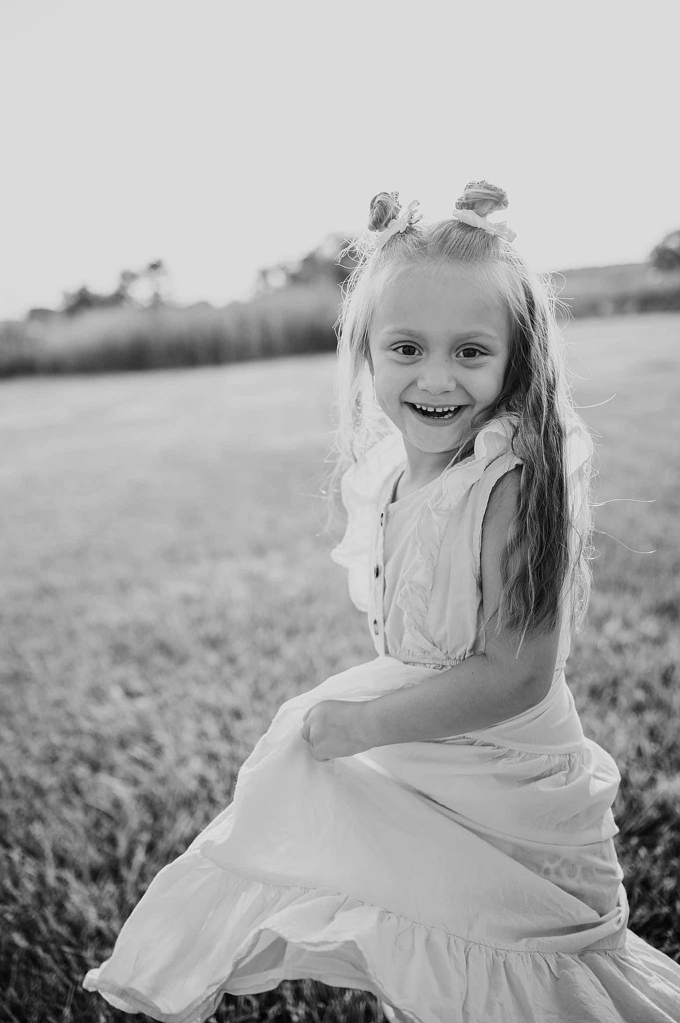 Kynzleigh is registered to the contest to win money with this photo: black_and_white, cloud, dress, eye, face, flash_photography, grass, grassland, happy, head, joy, meadow, monochrome, people_in_nature, person, plant, skin, sky, smile, style