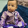 Praneeth Thunugunta joined the competition — help win amazing prizes! toddler, child, purple_clothing, traditional_outfit, indoor, portrait, face, curious, sitting, blue_background, infant, cute, young_child, baby, hands, expression, candid, soft_lighting, indoors, person
