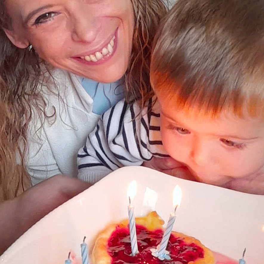 Samael participe au concours pour gagner de l'argent avec cette photo : birthday, cake, candles, celebration, child, closeup, curly_hair, dessert, face, family, food, happy, home, indoor, light, plate, smiling, striped_shirt, table, woman